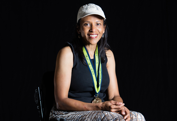 image of Karla Clay posing with her wheelchair games medal